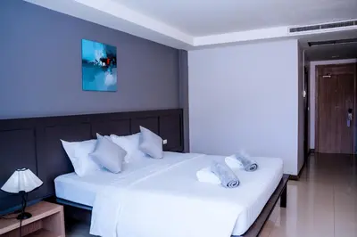 a bedroom with two beds with white sheets and pillows at Casa Del M Patong Phuket in Patong Beach