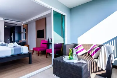 a hotel room with a bed and a couch at Casa Del M Patong Phuket in Patong Beach