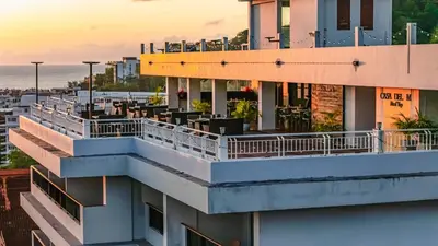 a view of a building with balconies and tables at Casa Del M Patong Phuket in Patong Beach