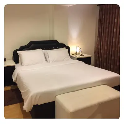 a bedroom with a large white bed and a stool at Apartment in Ranghill Residence Phuket by month in Phuket Town