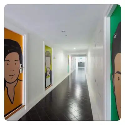 a hallway with paintings of faces on the walls at Apartment in Ranghill Residence Phuket by month in Phuket Town