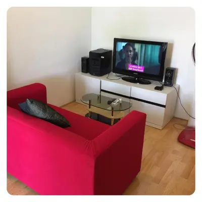 a living room with a red couch and a tv at Apartment in Ranghill Residence Phuket by month in Phuket Town