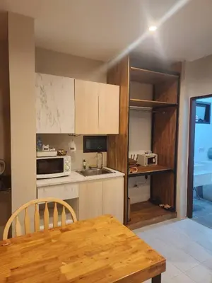 a kitchen with a wooden table and a counter top at Momento Bangtao Beach in Bang Tao Beach