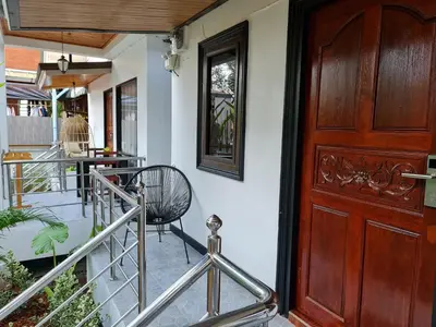 a wooden door and a chair on a porch at Momento Bangtao Beach in Bang Tao Beach