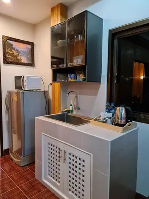 a kitchen with a sink and a refrigerator at Momento Bangtao Beach in Bang Tao Beach