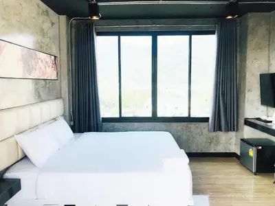 a bedroom with a white bed and a large window at My Style Resort Hotel -SHA Plus in Patong Beach