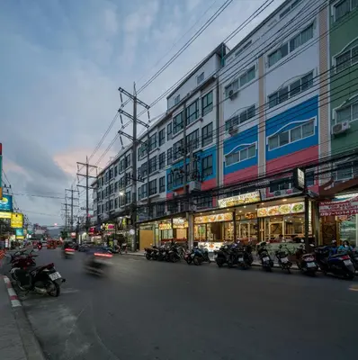 a city street with motorcycles parked in front of buildings at Baan Thai Beach Side Residence, Patong Beach in Patong Beach