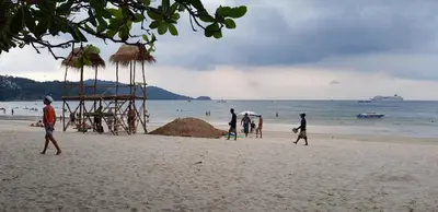 a group of people walking on a beach at Baan Thai Beach Side Residence, Patong Beach in Patong Beach