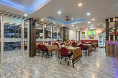 a restaurant with tables and chairs in a room at Baan Thai Beach Side Residence, Patong Beach in Patong Beach