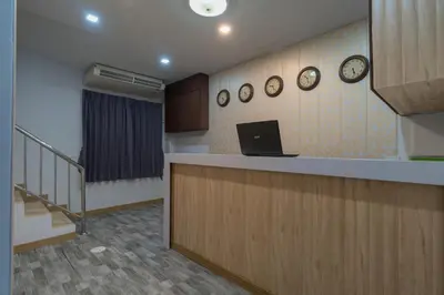 a office with a counter and clocks on the wall at Baan Thai Beach Side Residence, Patong Beach in Patong Beach
