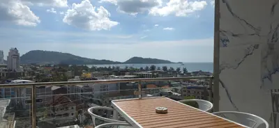 a table and chairs on a balcony with a view of the city at Villa Versace Residence in Patong Beach