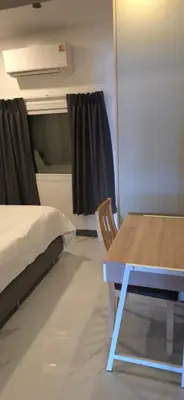 a room with a bed and a table and a chair at Villa Versace Residence in Patong Beach