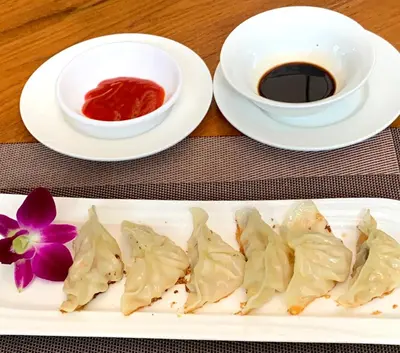 a plate of dumplings and a cup of coffee at Patong Heights in Patong Beach