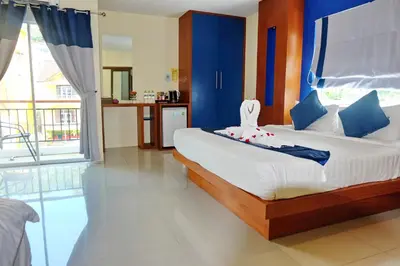 a bedroom with a large bed with blue walls at Calypso Patong Hotel in Patong Beach