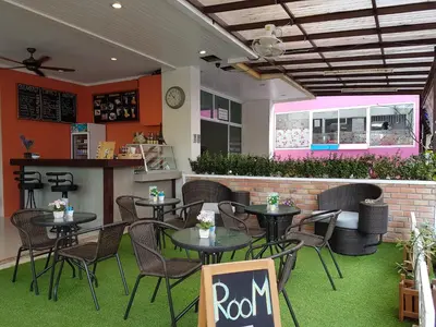 a restaurant with tables and chairs and a bar at Calypso Patong Hotel in Patong Beach