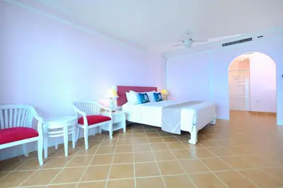 a bedroom with a bed and two chairs and a table at Andaman Beach Suites Hotel, Patong Phuket in Patong Beach