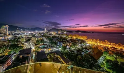 a city at night with the ocean and buildings at Andaman Beach Suites Hotel, Patong Phuket in Patong Beach