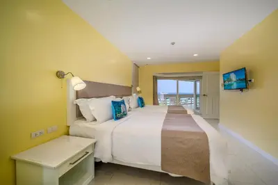 a bedroom with a large bed with a view of the ocean at Andaman Beach Suites Hotel, Patong Phuket in Patong Beach
