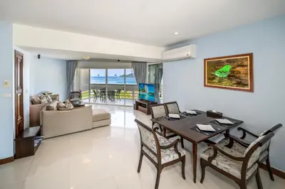 a living room with a dining table and a couch at Andaman Beach Suites Hotel, Patong Phuket in Patong Beach