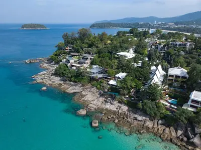 an aerial view of a resort on a rocky island in the water at Mom Tri's Villa Royale - SHA Plus in Kata Beach