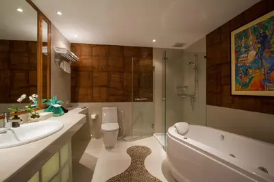 a bathroom with a sink and a tub and a toilet at Mom Tri's Villa Royale - SHA Plus in Kata Beach