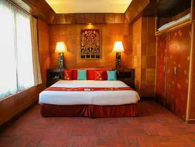 a bedroom with a large bed with red pillows at Mom Tri's Villa Royale - SHA Plus in Kata Beach