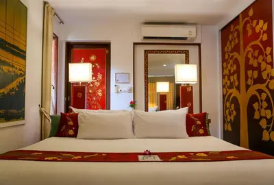 a bedroom with a large bed with white pillows at Mom Tri's Villa Royale - SHA Plus in Kata Beach