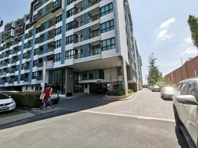 a woman walking in front of a building at 5 Floor - Centrio Condominium in Phuket Town - 30 mins to beaches in Phuket Town