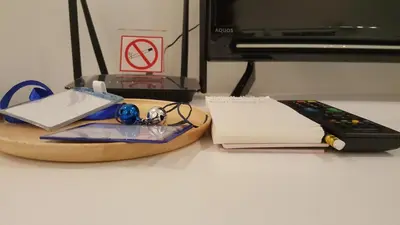 a desk with a remote control and a book at Wora Stay room Kata beach in Kata Beach