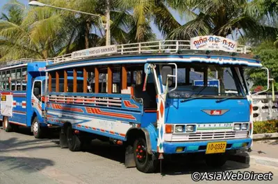 two blue buses parked on the side of a street at Wora Stay room Kata beach in Kata Beach
