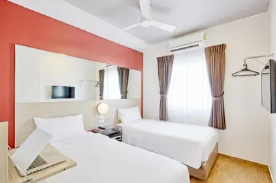 a hotel room with two beds and a tv at Easy Planet Phuket Patong in Patong Beach