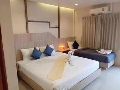 two beds in a hotel room with towels on them at The Way Patong Hotel in Patong Beach