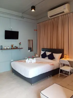a bedroom with a large bed with a tv on the wall at The Way Patong Hotel in Patong Beach