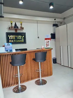 a bar with two black stools in a room at The Way Patong Hotel in Patong Beach