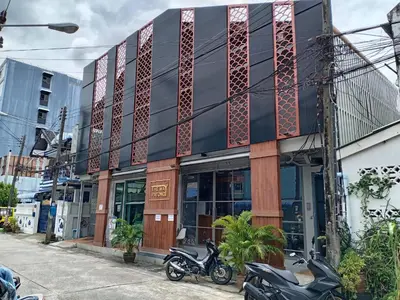 a building on a street with motorcycles parked in front at The Way Patong Hotel in Patong Beach