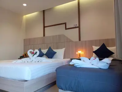 two beds in a room with swans on them at The Way Patong Hotel in Patong Beach
