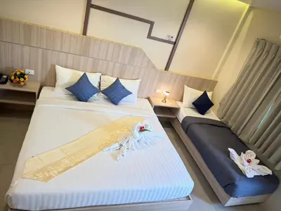 a bedroom with two beds with towels on them at The Way Patong Hotel in Patong Beach