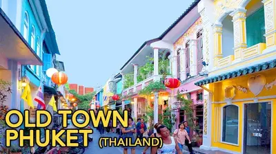 a group of people walking down a street in an old town at D2 lamoon resotel in Phuket Town