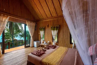 a bedroom with a bed and a large window at The Cove Phi Phi in Phi Phi Don