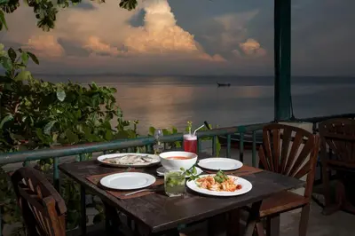 a table with two plates of food on a balcony at The Cove Phi Phi in Phi Phi Don