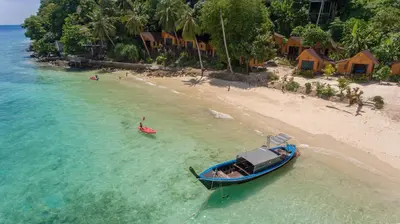 a boat in the water next to a beach at The Cove Phi Phi in Phi Phi Don