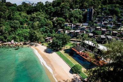 an aerial view of a resort on a beach at The Naka Phuket, a member of Design Hotels in Kamala Beach