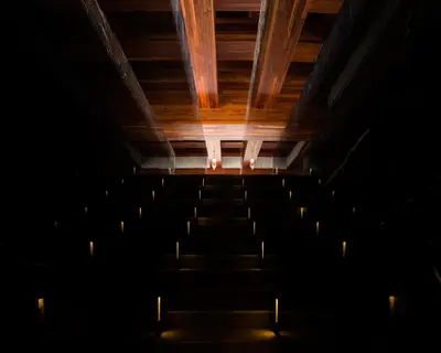an empty auditorium with a wooden ceiling and chairs at The Naka Phuket, a member of Design Hotels in Kamala Beach