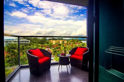 a balcony with two chairs and a table in front of a window at The Aristo by Holy Cow, 2-BR, mountain view in Bang Tao Beach