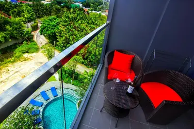 a balcony with a chair and a swimming pool at The Aristo by Holy Cow, 2-BR, mountain view in Bang Tao Beach