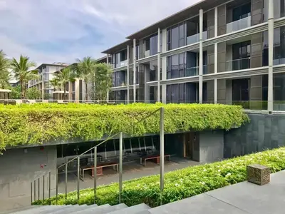 an ivy covered building with benches in front of it at Baan mai khao apartment in Mai Khao Beach