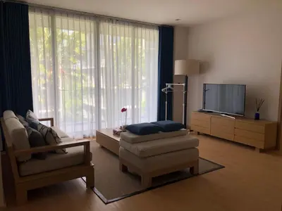 a living room with a couch chair and a television at Baan mai khao apartment in Mai Khao Beach