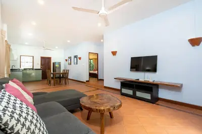 a living room with a couch and a flat screen tv at Thai Style 2BR Villa Nikkie 2 in Nai Harn Beach