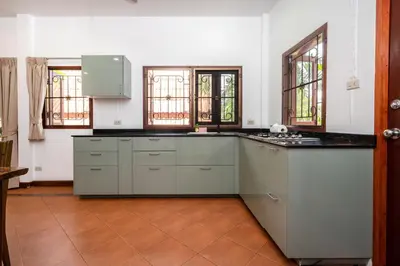 a kitchen with white cabinets and a counter top at Thai Style 2BR Villa Nikkie 2 in Nai Harn Beach