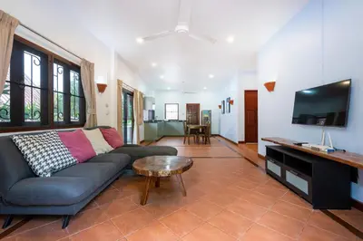 a living room with a couch and a flat screen tv at Thai Style 2BR Villa Nikkie 2 in Nai Harn Beach